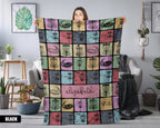 Person holding a colorful patterned blanket with name text printed on it in a room setting.