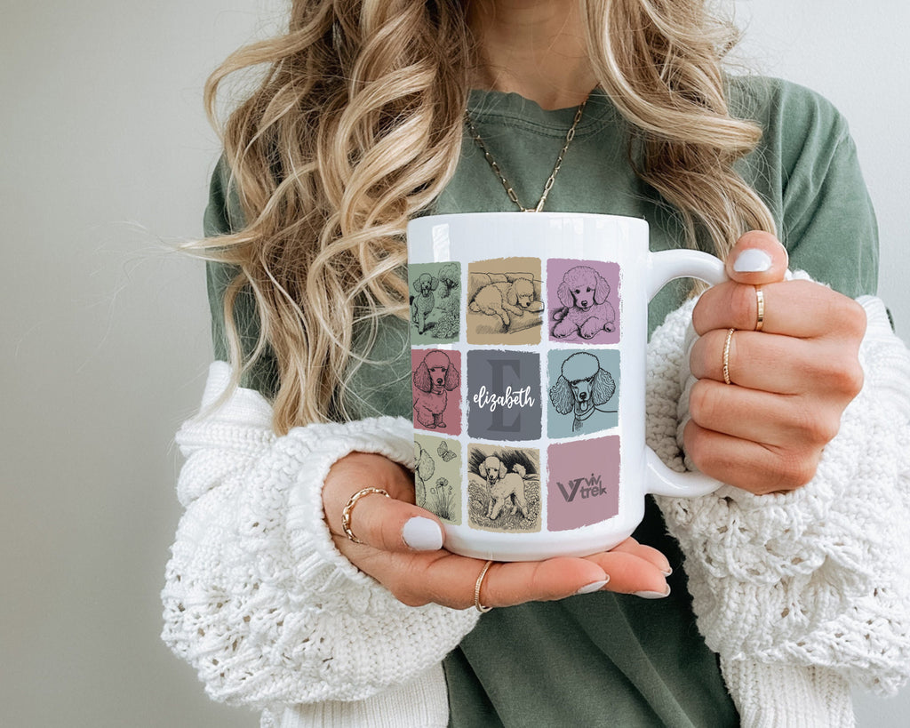 Person holding a mug with a colorful design and initial name text.