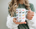 Person holding a mug with colorful dachshund patterns and the name