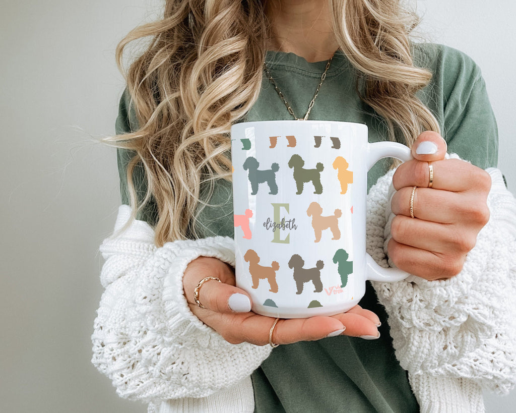 Person holding a mug with dog illustrations and the name text.