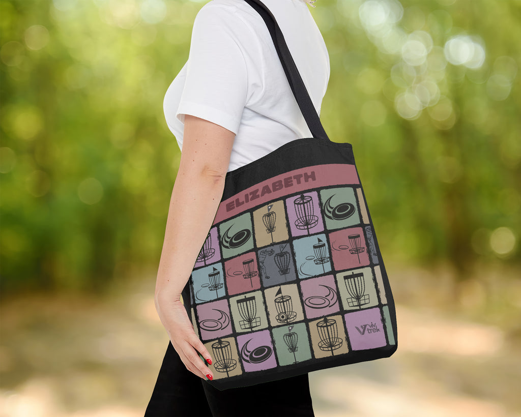 Person holding a tote bag with a pattern and text