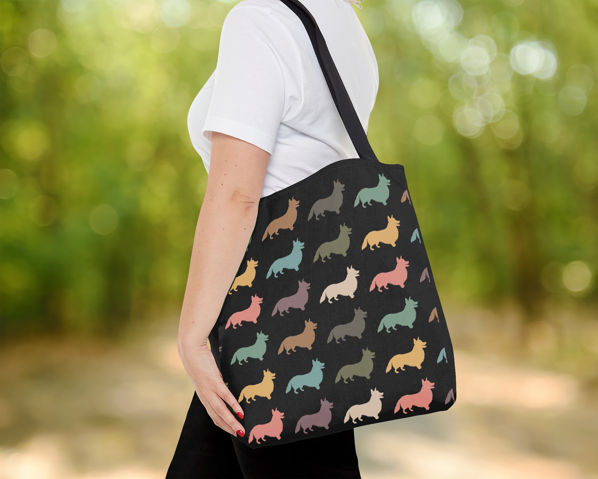 Person holding a tote bag with colorful dog pattern outdoors